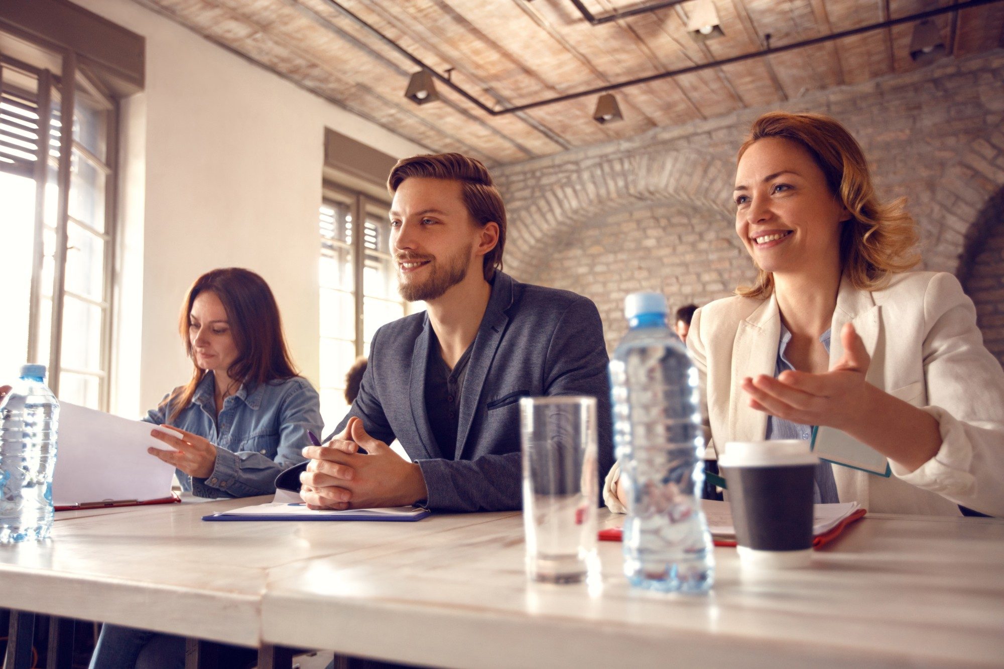 Three admissions staff smile across a table during an interview
