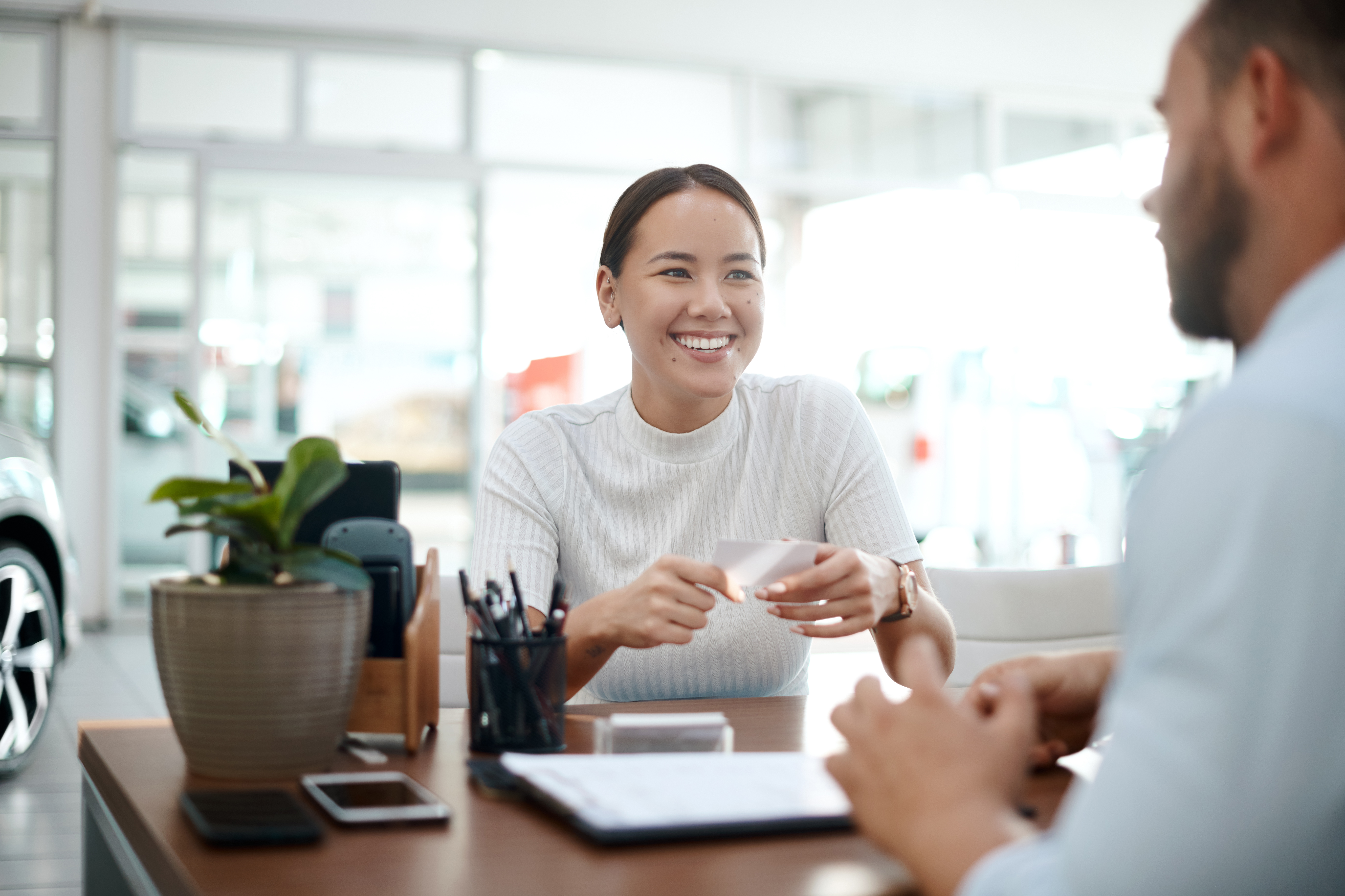 A customer smiles across the desk from a finance manager