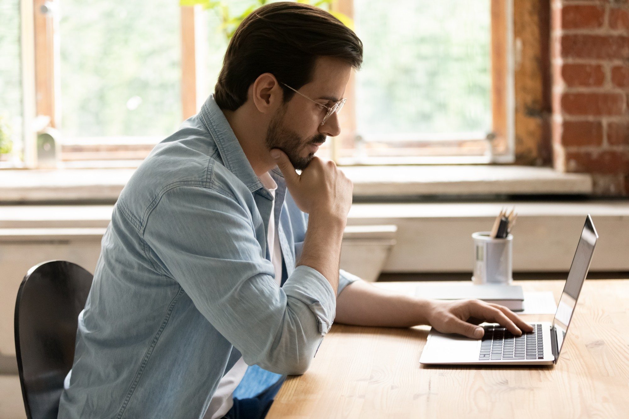 A sales manager reviews a rep's visit scores on his laptop